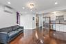 Living room with crown molding, dark wood finished floors, a wall unit AC, recessed lighting, and electric panel