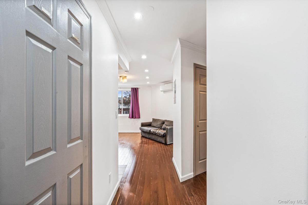 Corridor featuring ornamental molding, recessed lighting, dark wood-style floors, and an AC wall unit