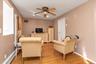 Living room with baseboard heating, light wood-type flooring, ceiling fan, and recessed lighting