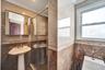Full bath featuring tile walls, a stall shower, and crown molding