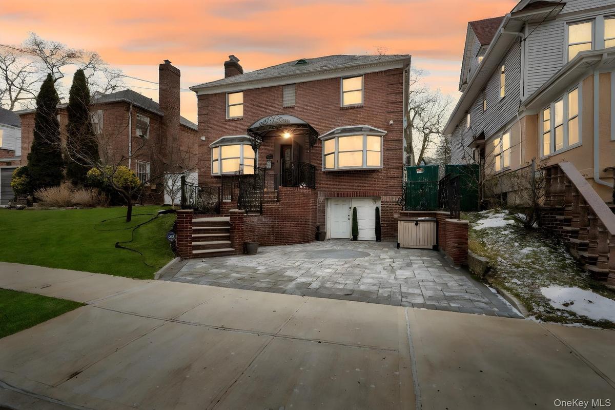 American foursquare style home with brick siding, a front yard, and a chimney