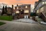 American foursquare style home with brick siding, a front yard, and a chimney