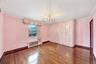 Unfurnished room featuring dark wood-style floors, radiator heating unit, a chandelier, and ornamental molding