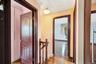 Corridor featuring dark wood-style floors, attic access, and crown molding