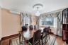 Dining area featuring a wall mounted AC, dark wood-type flooring, and crown molding