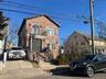 View of front of home with brick siding and a balcony