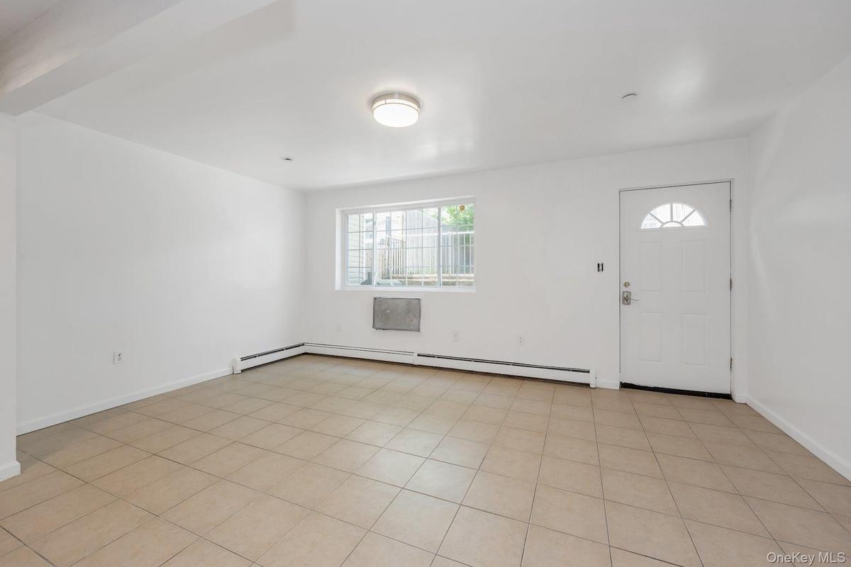 Foyer entrance featuring baseboards and a baseboard heating unit