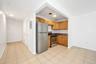 Kitchen featuring stainless steel appliances, light tile patterned flooring, electric panel, and brown cabinets