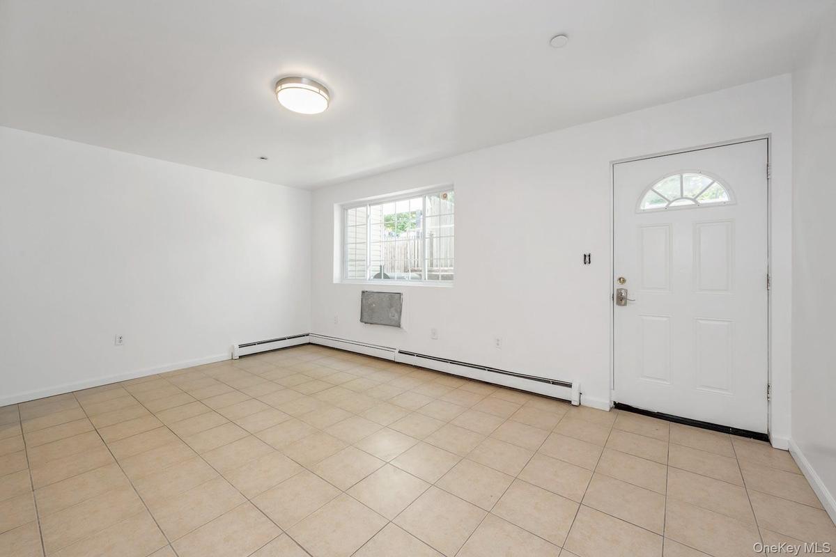 Foyer with a baseboard radiator and light tile patterned flooring