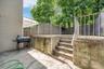 Fenced backyard with area for grilling and a patio area