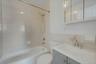 Full bath with vanity, tile walls,  shower combination, and tasteful backsplash