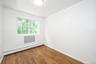 Unfurnished room featuring baseboard heating and hardwood / wood-style flooring