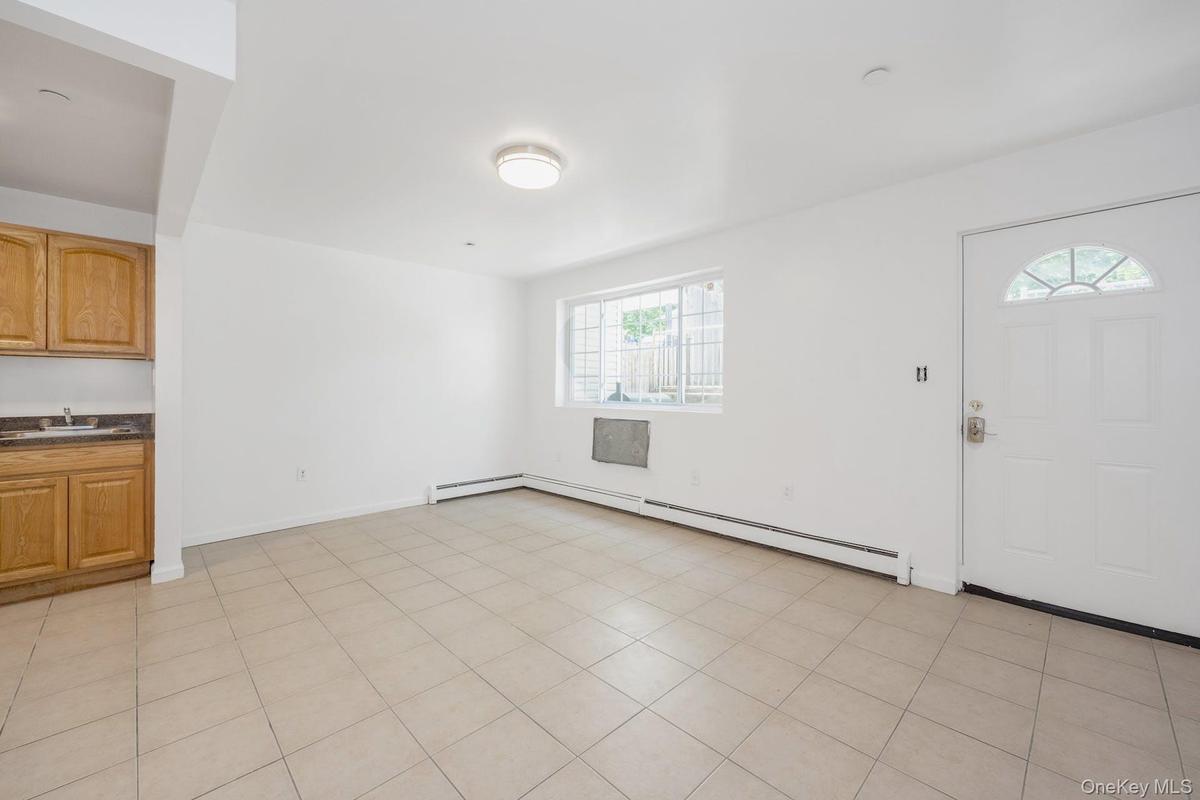 Foyer featuring a baseboard heating unit and light tile patterned flooring