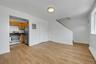 Kitchen featuring stainless steel range with gas cooktop, a baseboard heating unit, light wood-style floors, freestanding refrigerator, and dark count