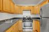 Kitchen with stainless steel appliances, dark countertops, and light brown cabinets