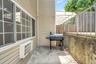 View of patio featuring area for grilling and an AC wall unit