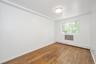Spare room featuring a baseboard radiator and hardwood / wood-style floors