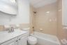 Full bathroom with  shower combination, vanity, and tile walls