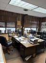 Office area with a drop ceiling and wooden walls