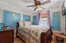 Bedroom featuring ornamental molding, light wood-style flooring, and ceiling fan