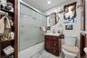 Full bath featuring tile walls, enclosed tub / shower combo, and vanity