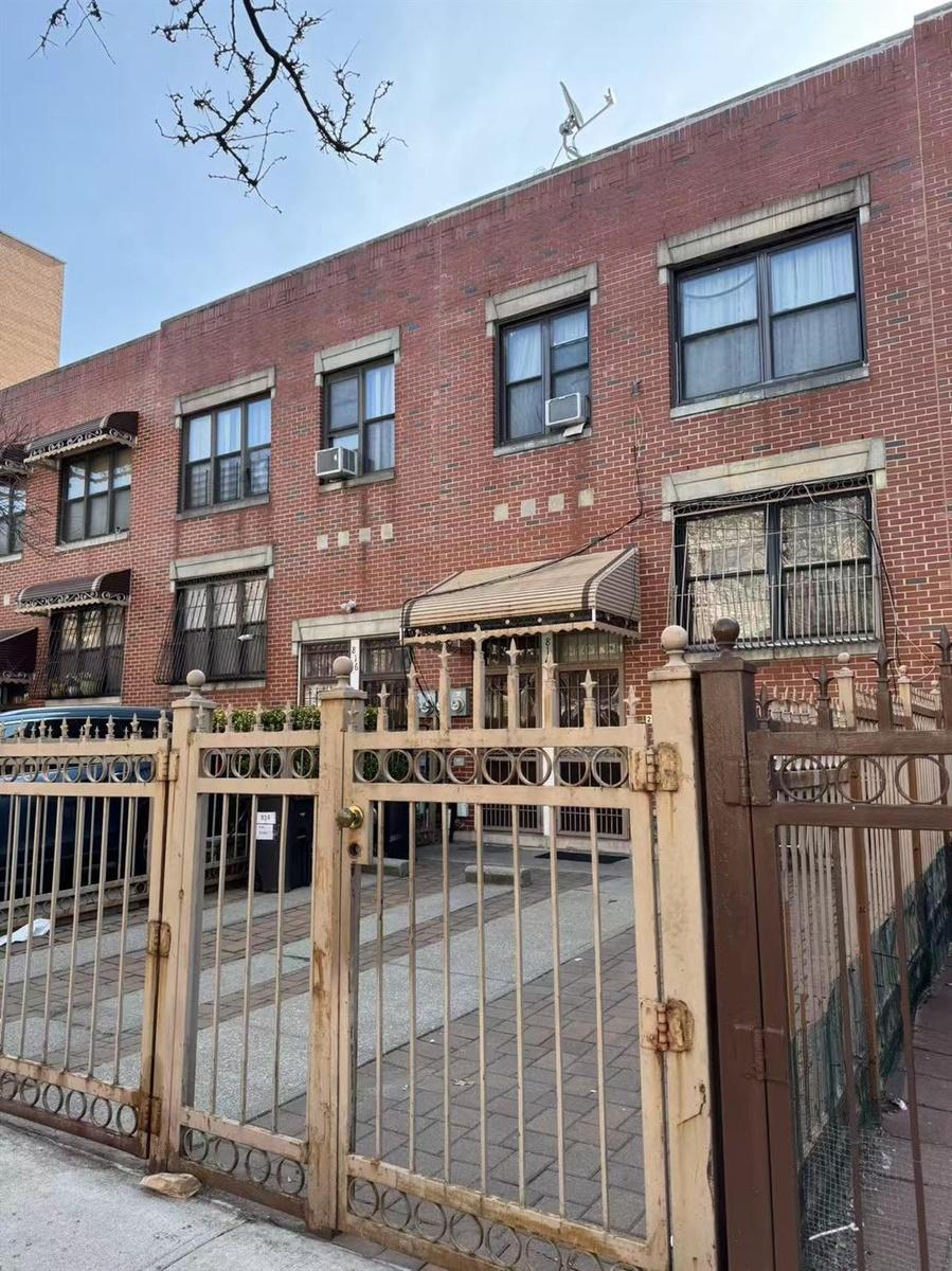 Townhome / multi-family property with cooling unit, brick siding, a gate, and a fenced front yard