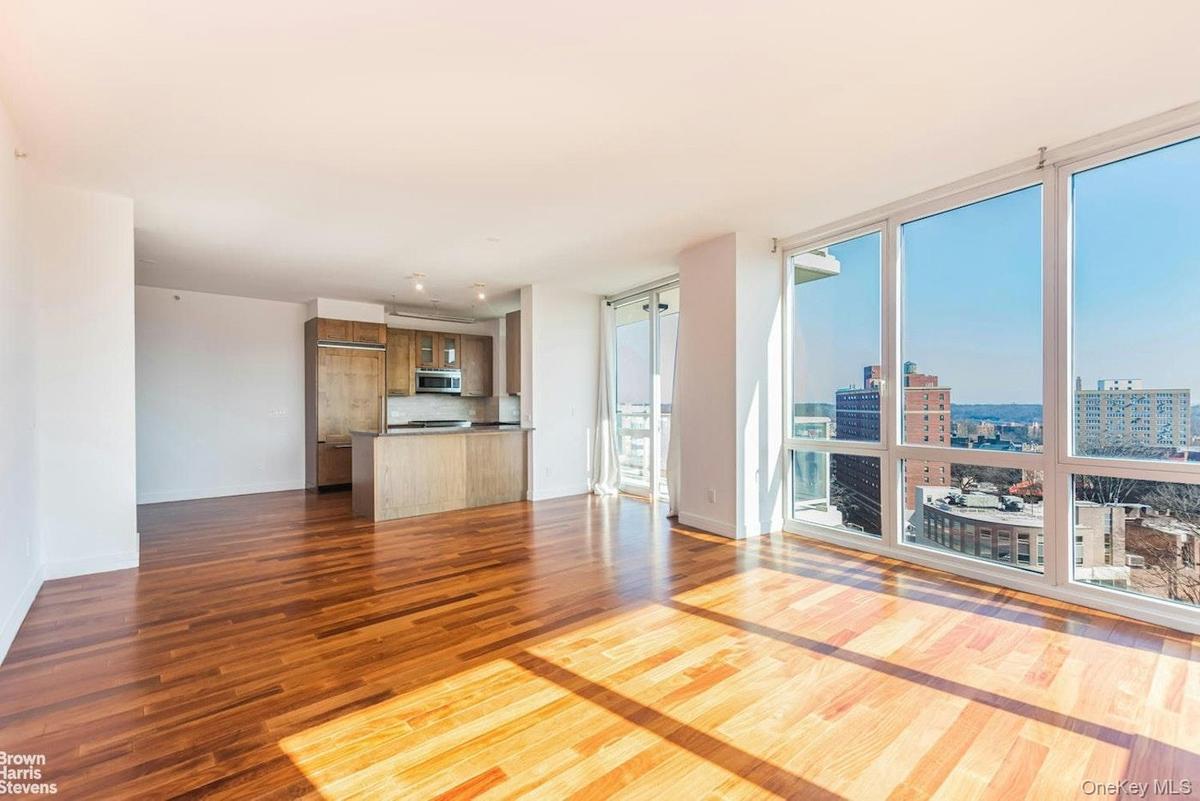 Unfurnished living room featuring dark wood-style flooring, expansive windows, a view of city, and baseboards