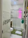 Full bath with vanity, a stall shower, and tile walls