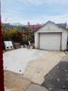 Detached garage featuring concrete driveway
