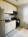 Kitchen featuring white cabinetry, stainless steel appliances, light marble finish floors, and butcher block countertops