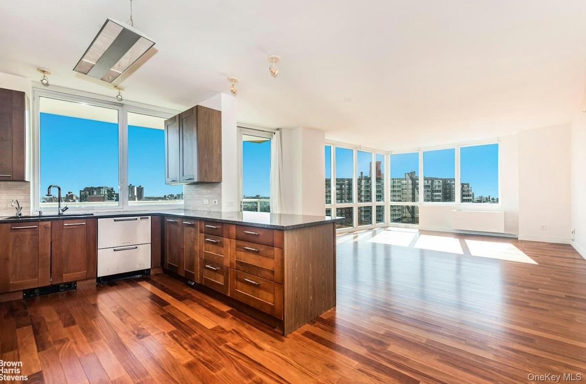 Kitchen with dishwashing machine, dark wood-style flooring, a peninsula, tasteful backsplash, and a sink