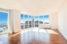 Spare room featuring a view of city, hardwood / wood-style floors, floor to ceiling windows, and baseboards