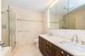 Full bathroom with tile walls, dual vanity, separate shower and tub, toilet, and tile patterned flooring