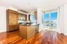 Kitchen featuring stainless steel microwave, brown cabinets, a peninsula, and dark wood-style flooring