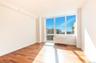 Empty room featuring light hardwood / wood-style floors, radiator, and plenty of natural light