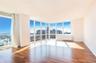Unfurnished room featuring radiator heating unit, floor to ceiling windows, and hardwood / wood-style floors