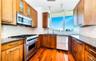 Kitchen with appliances with stainless steel finishes, dark hardwood / wood-style flooring, decorative backsplash, and sink