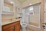 Full bath featuring tiled shower / bath, vanity, and light tile patterned flooring