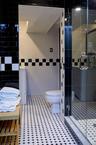 Bathroom with tile walls, a stall shower, and tile patterned floors