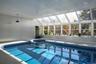 View of pool featuring a pool with connected hot tub, a skylight, and a sunroom