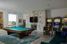 Rec room featuring a stone fireplace, billiards, recessed lighting, and a baseboard heating unit