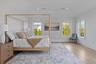 An expansive water view primary ensuite bedroom filled with natural light