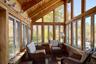 Sunroom / solarium with healthy amount of natural light, hardwood / wood-style flooring, a wood ceiling with exposed beams, and high vaulted ceiling