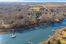 A bird's eye perspective showcasing the home's commanding waterfront position, expansive grounds and serene North Fork setting