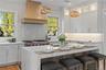 A showpiece kitchen featuring quartz countertops, full overlay cabinetry with glass uppers to the ceiling, and a premium Sub_Zero, Wolf and Miele appl