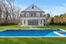 Back of property with a lawn, a patio area, and an outdoor pool