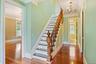 Staircase with a chandelier, crown molding, and hardwood / wood-style flooring