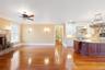 Kitchen with a fireplace with raised hearth, open floor plan, backsplash, light wood finished floors, and ornamental molding