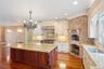 Kitchen with ornamental molding, light stone counters, tasteful backsplash, hanging light fixtures, and recessed lighting