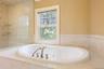 Full bath featuring a jetted tub and tiled shower